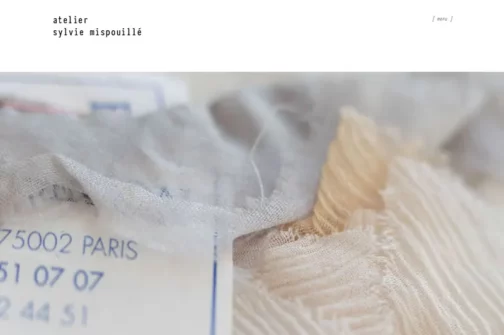 Capture d'écran de la page d'accueil du site de Sylvie Mispouillé: gros plan sur des étoffes précieuses utilisées dans la confection de robe de mariée.